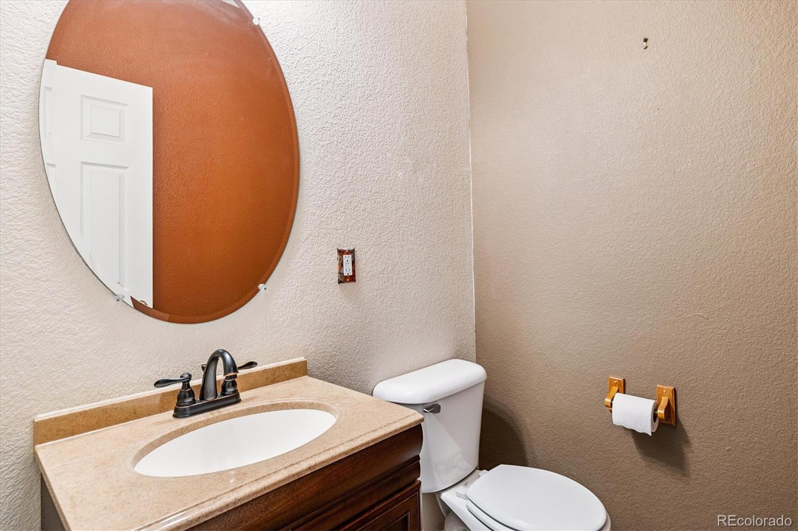 4658 Flower Street Wheat Ridge, CO 80033 - Photo 15 of 26 a bathroom with a sink a toilet and mirror