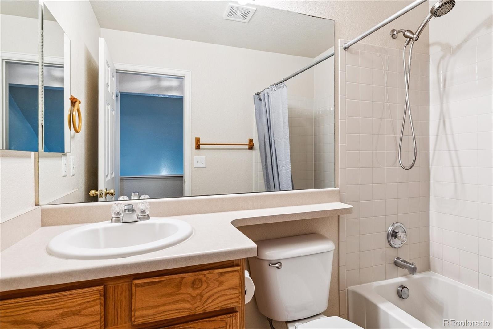 4658 Flower Street Wheat Ridge, CO 80033 - Photo 17 of 26 a bathroom with a sink a toilet and a bathtub