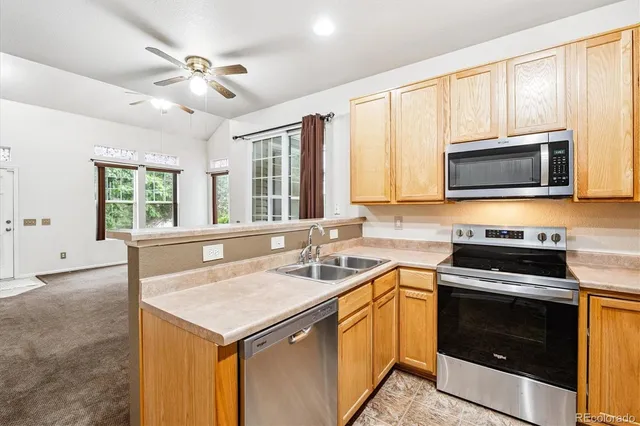 a kitchen with stainless steel appliances granite countertop a stove microwave and sink