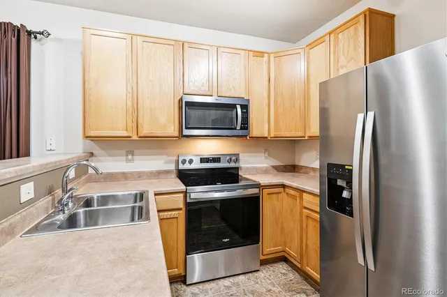 a kitchen with stainless steel appliances granite countertop a refrigerator stove and sink
