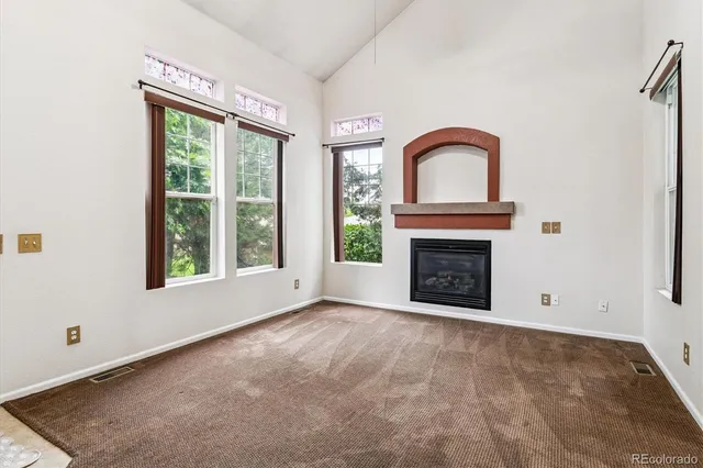 a view of an empty room with a fireplace and a window