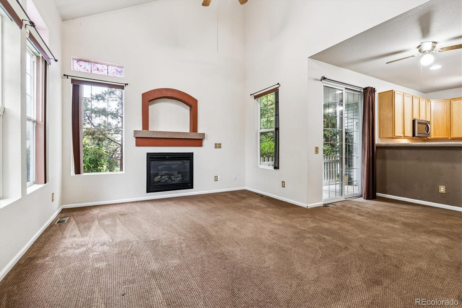 4658 Flower Street Wheat Ridge, CO 80033 - Photo 9 of 26 a view of an empty room with a fireplace and a window