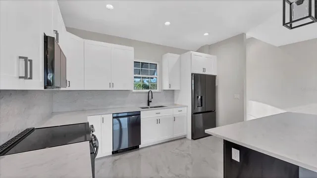 a kitchen with stainless steel appliances granite countertop a refrigerator sink and stove