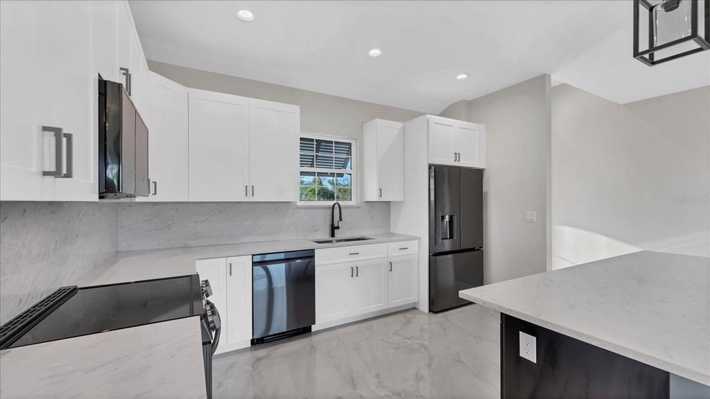 242 Brig Circle West Placida, FL 33946 - Photo 11 of 30 a kitchen with stainless steel appliances granite countertop a refrigerator sink and stove