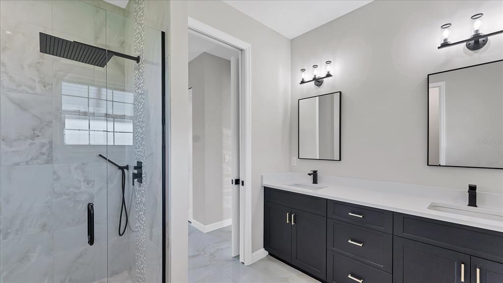 242 Brig Circle West Placida, FL 33946 - Photo 18 of 30 a bathroom with a double vanity sink a mirror and a shower