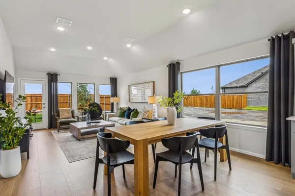 a kitchen with stainless steel appliances granite countertop a stove top oven a sink a stove and white cabinets with wooden floor