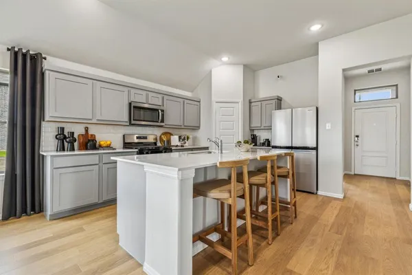 a kitchen with lots of counter top space a sink appliances and cabinets