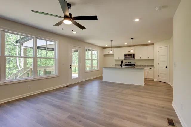 a view of an empty room with kitchen appliances and a window