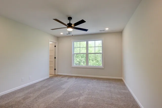 an empty room with a window and a fan