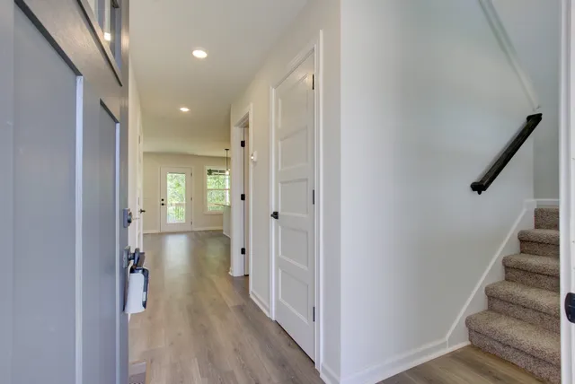 a view of a hallway with wooden floor and staircase