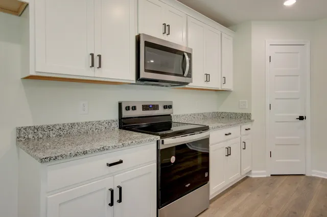 a kitchen with stainless steel appliances granite countertop a stove a microwave and cabinets
