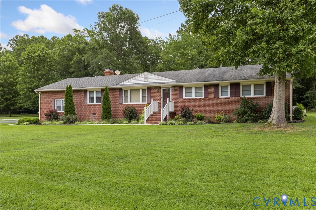 Ranch-style house with a front lawn, brick siding,