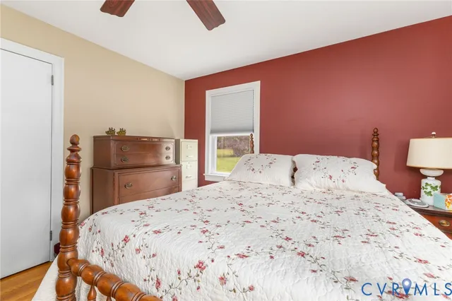 a bedroom with a bed and dresser with mirror