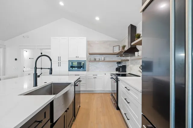 a kitchen with stainless steel appliances granite countertop a sink stove and refrigerator