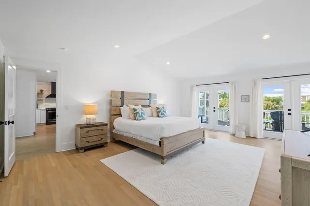 a spacious bedroom with a bed and a flat screen television