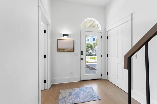 a view of a livingroom with wooden floor stairs and a bathroom