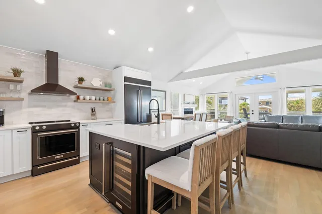 a kitchen with stainless steel appliances granite countertop a table chairs sink and stove top oven