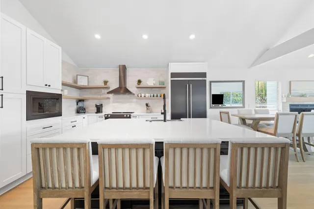 a kitchen with kitchen island a table and chairs
