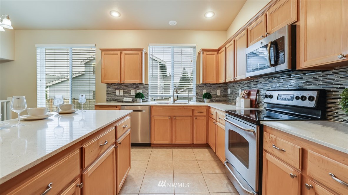 6725 Southeast 3rd Street Renton, WA 98059 - Photo 12 of 32 a kitchen with stainless steel appliances granite countertop a stove a sink and a microwave