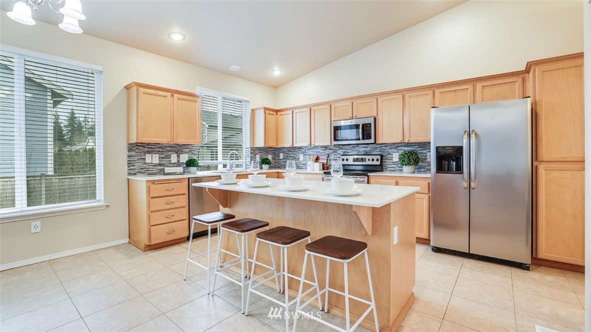 6725 Southeast 3rd Street Renton, WA 98059 - Photo 8 of 32 a kitchen with kitchen island granite countertop a stove a sink a refrigerator and a cabinets