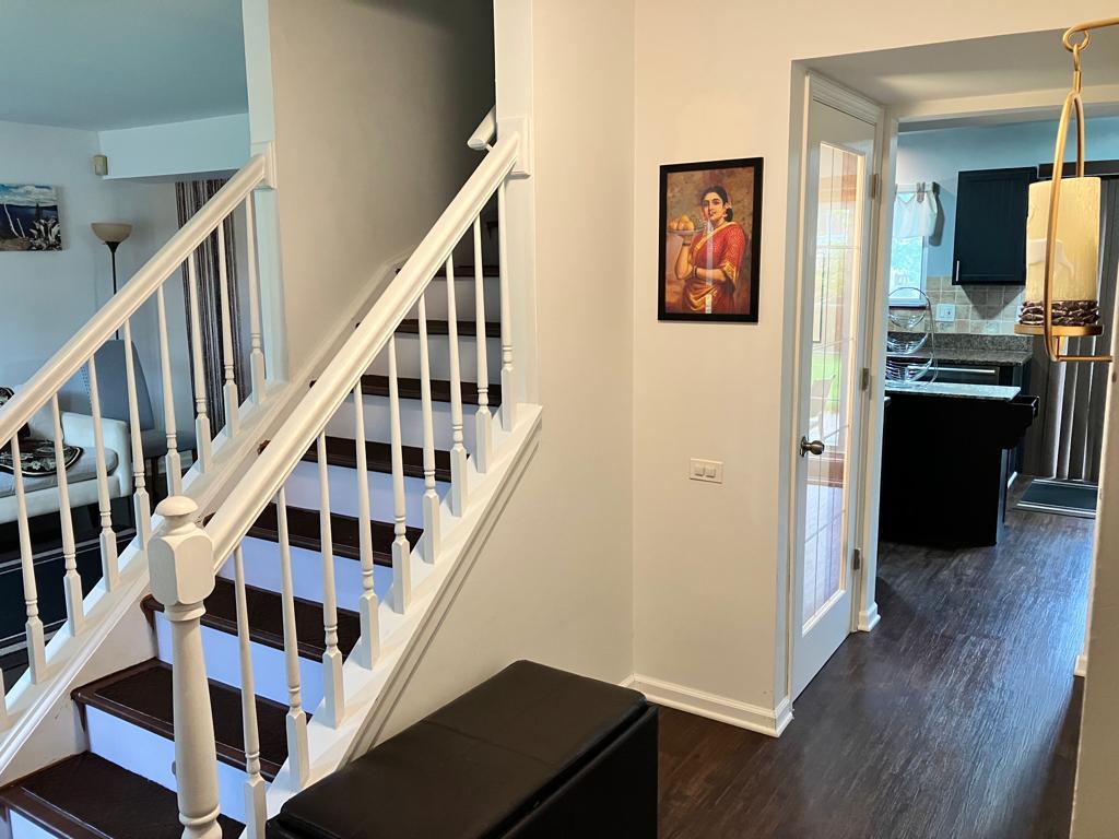 Undisclosed Address Round Lake Beach, IL 60073 - Photo 2 of 28 a view of a hallway with wooden floor and staircase