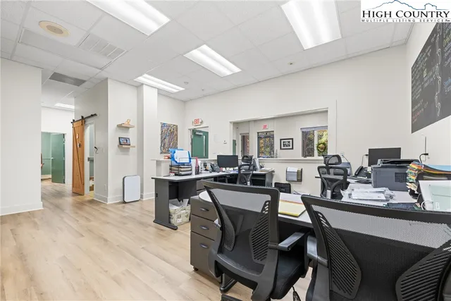 a dining hall with stainless steel appliances kitchen island granite countertop furniture and wooden floor