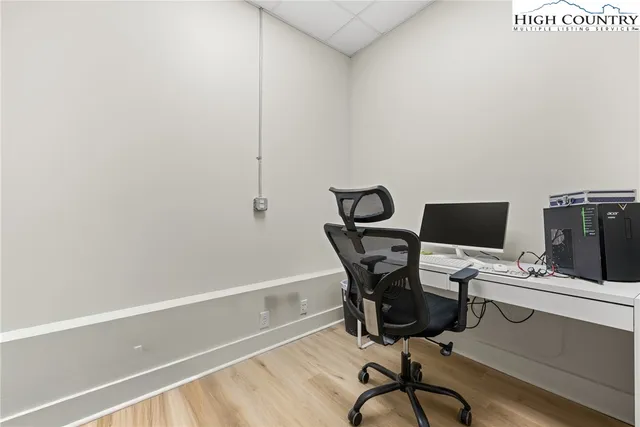a view of a workspace with furniture and a window