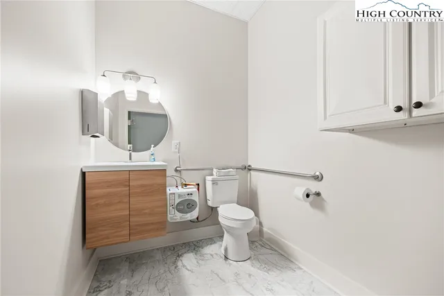 a bathroom with a toilet a sink and mirror