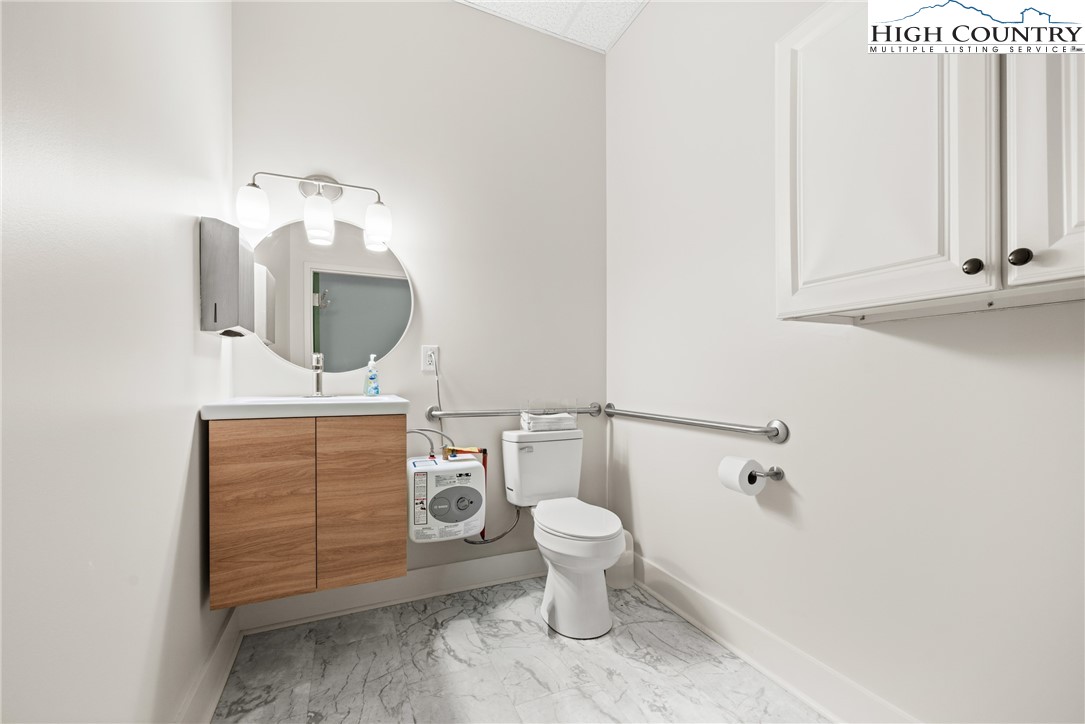 610 State Farm Road, Unit 3 Boone, NC 28607 - Photo 44 of 49 a bathroom with a toilet a sink and mirror