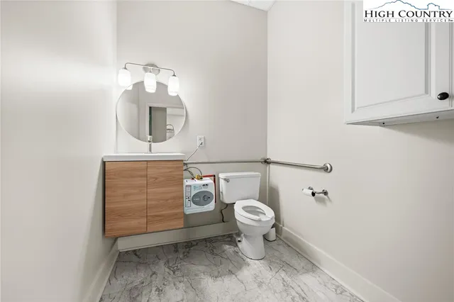 a bathroom with a toilet a sink and mirror