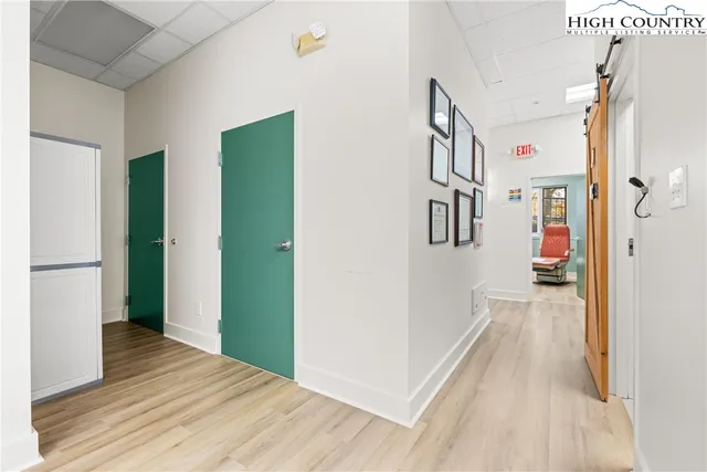 a view of a hallway with wooden floor and entryway