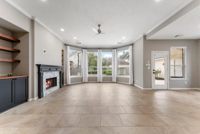 a view of an empty room with a fireplace and a window