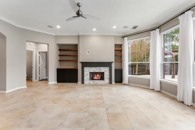 a view of an empty room with a fireplace and a window