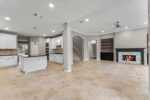 a large kitchen with a large counter top stainless steel appliances and cabinets