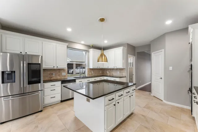 a kitchen with granite countertop a sink and white stainless steel appliances