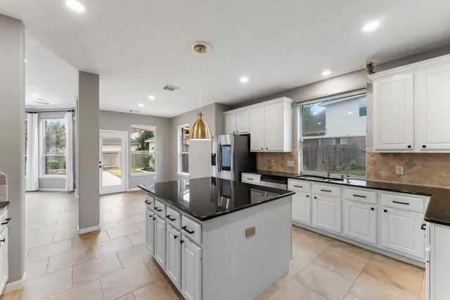 a kitchen with granite countertop a sink and cabinets