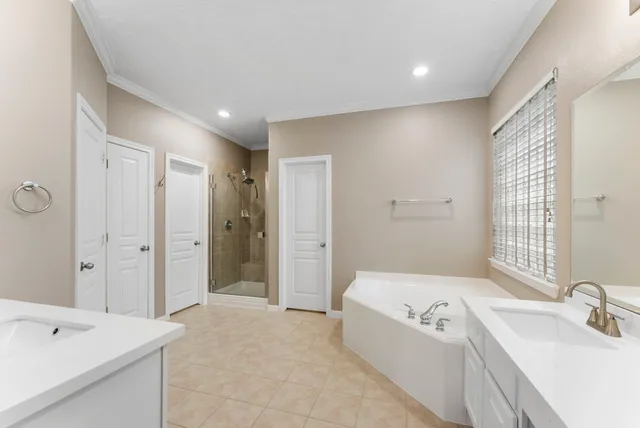 a spacious bathroom with a tub sink and mirror