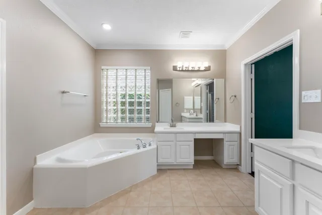 a spacious bathroom with a large tub sink and mirror