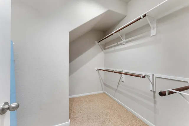 a view of walk in closet with empty racks
