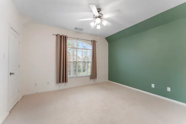 an empty room with windows and fan