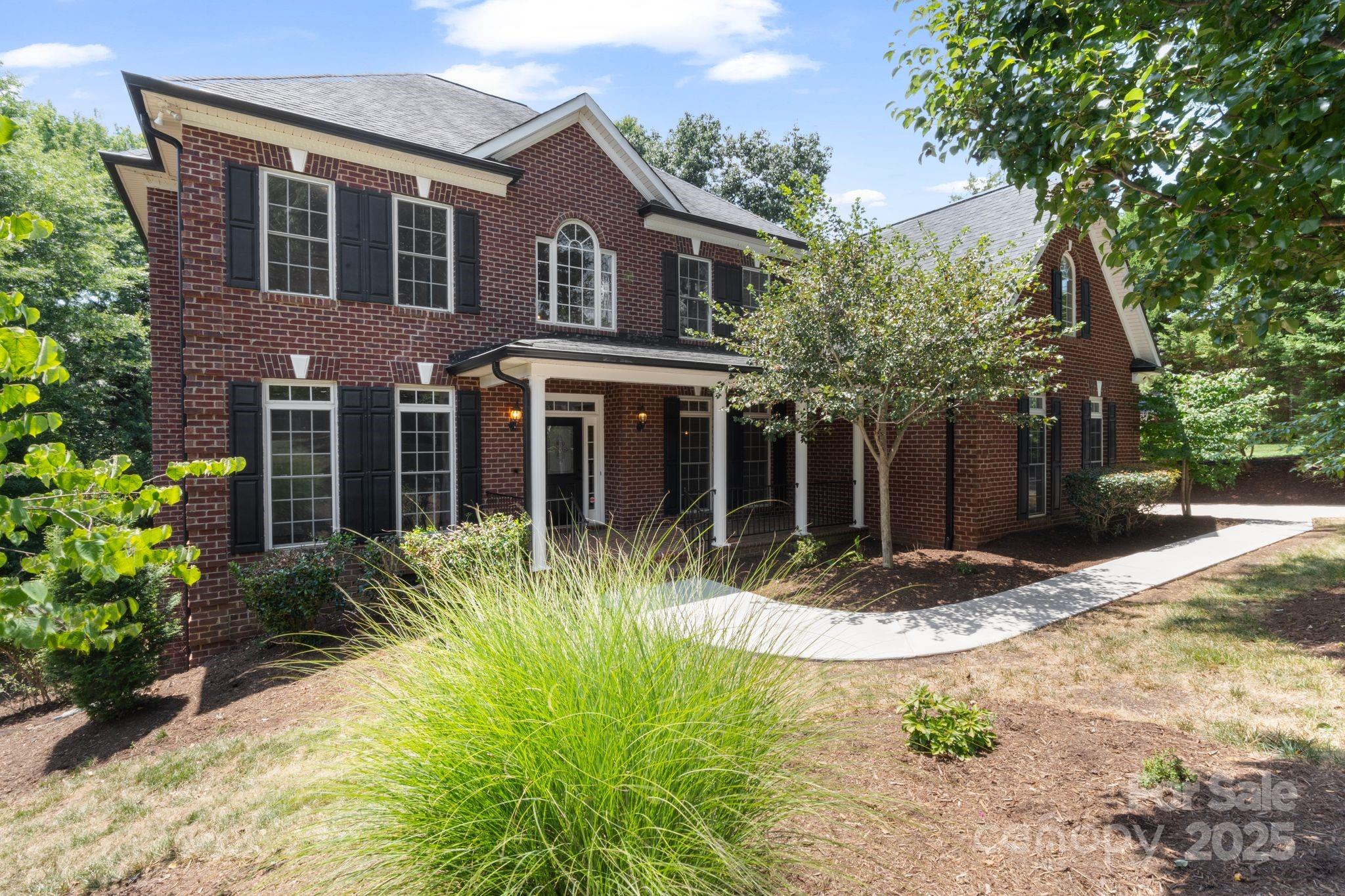 3211 Planters Ridge Road Charlotte, NC 28270 - Photo 1 of 43 a view of a brick house with plants and large tree
