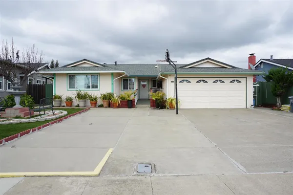 a view of a white house with a yard and plants