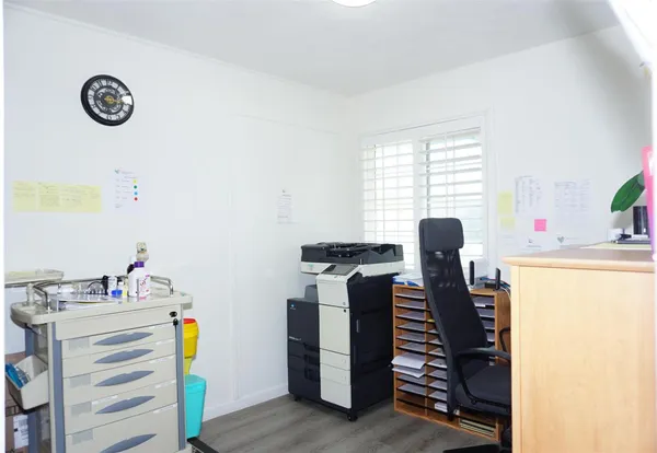 a view of a workspace with furniture and a window