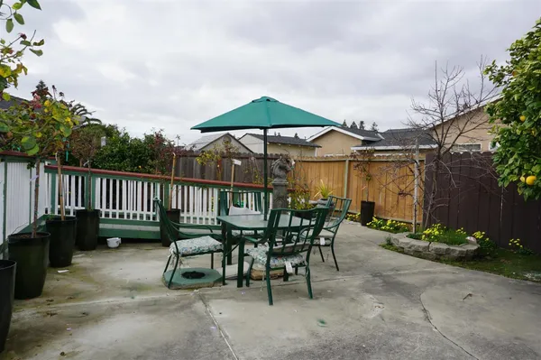 a view of a chairs and table in the back yard of the house