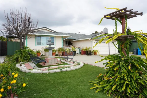 a view of a house with backyard and sitting area