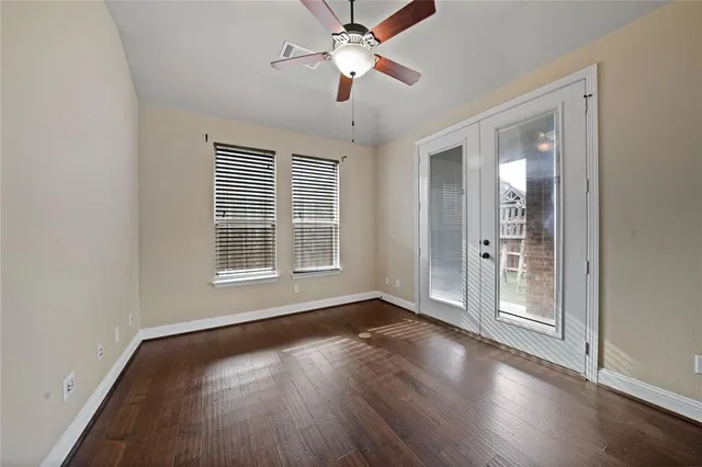 a view of an empty room with wooden floor a fireplace and a window