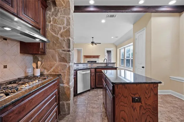 a kitchen with kitchen island a counter space a sink and a stove