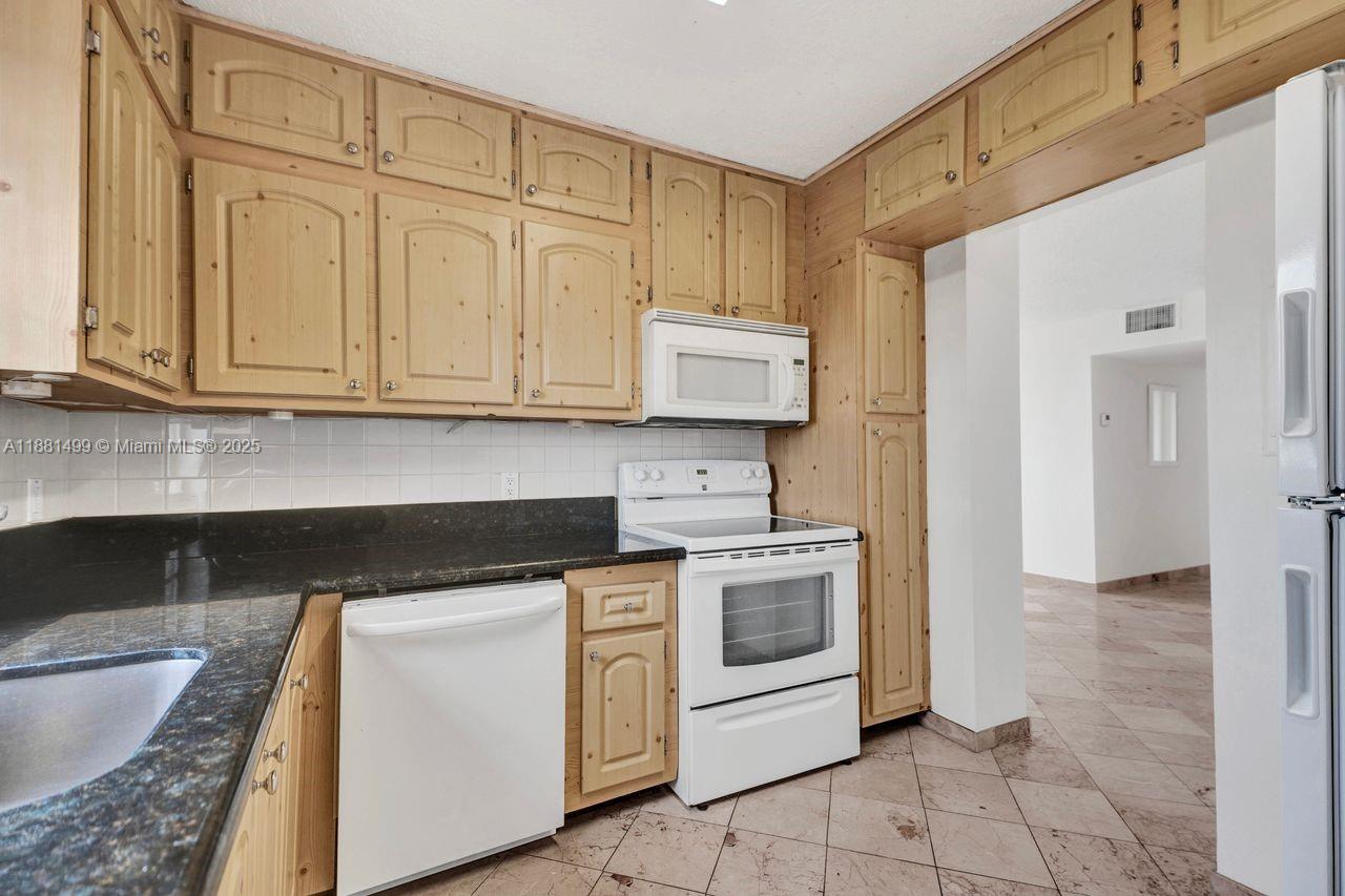 2025 Northeast 164th Street, Unit 716 North Miami Beach, FL 33162 - Photo 1 of 39 a kitchen with stainless steel appliances granite countertop a stove a sink and a white cabinets