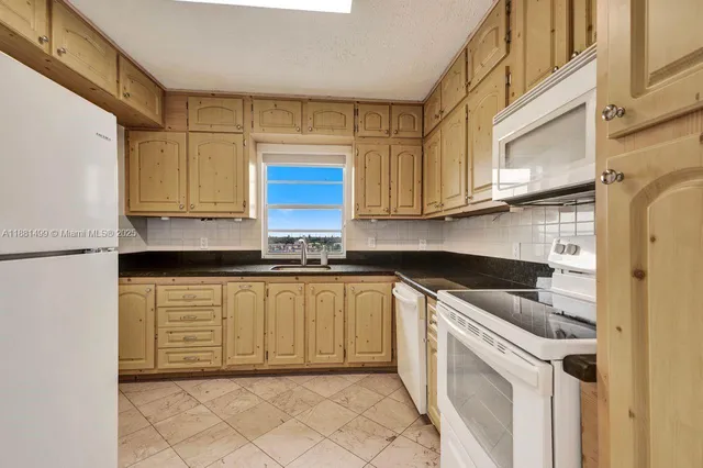 a kitchen with stainless steel appliances granite countertop a sink and a stove