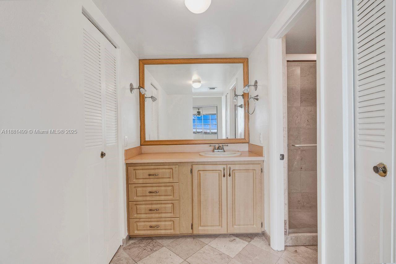 2025 Northeast 164th Street, Unit 716 North Miami Beach, FL 33162 - Photo 28 of 39 a spacious bathroom with a mirror and a sink